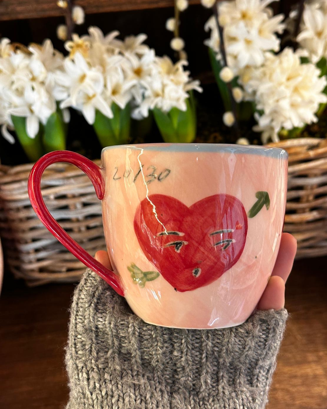 Ceramic mug with a red heart design hand painted by Tatiana Alida for Valentine's gifting